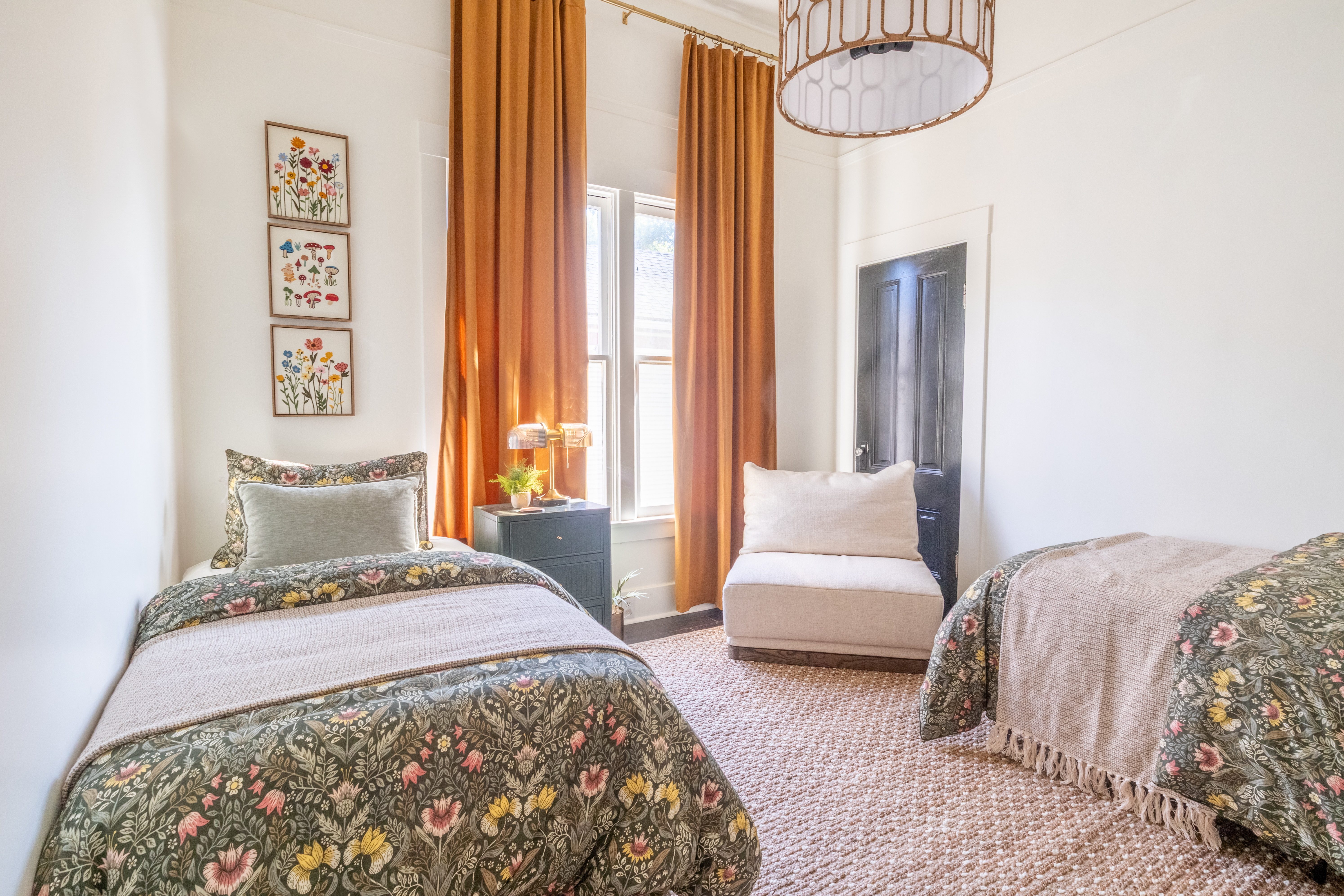 Guest bedroom with two twin beds and orange curtains