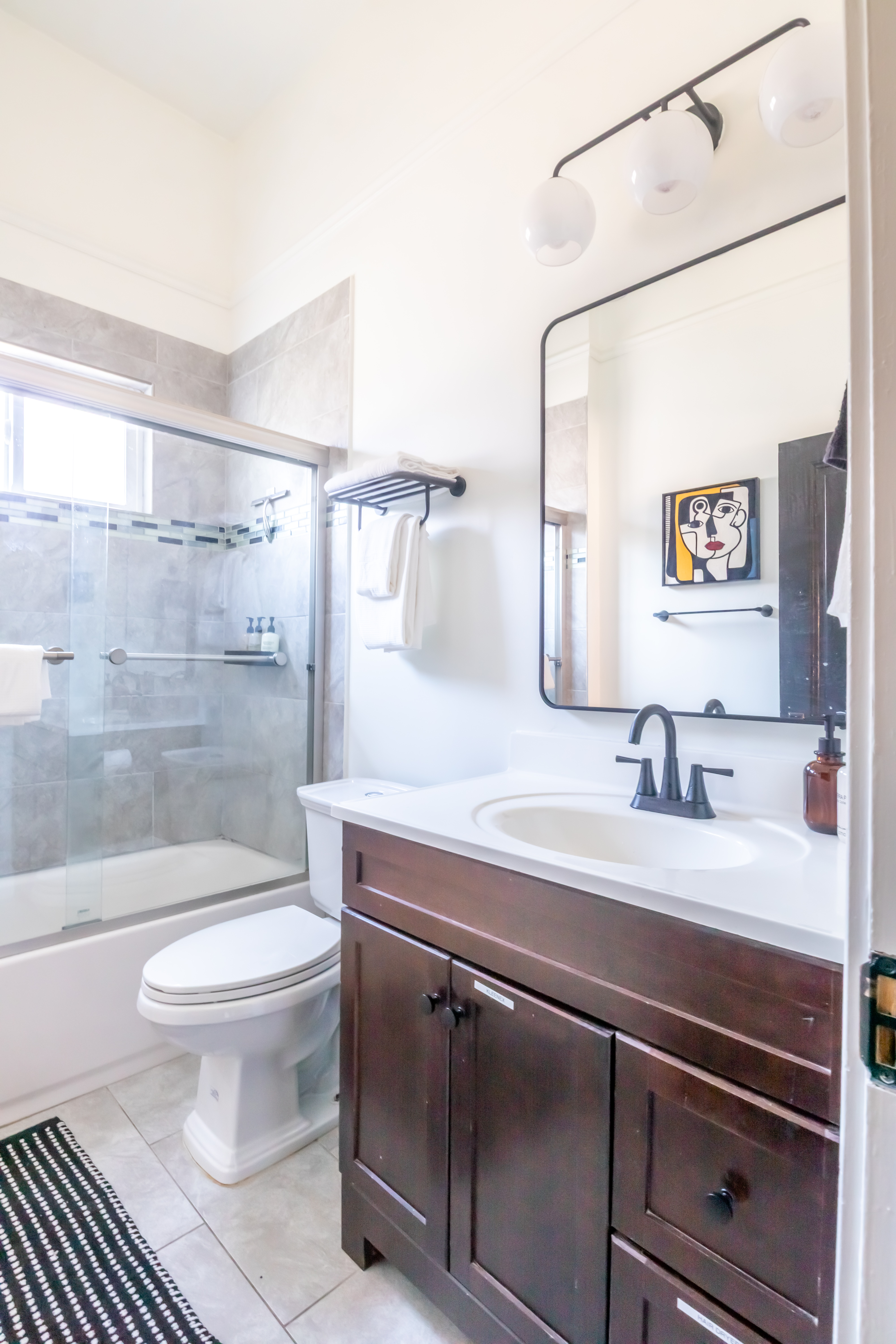 Bathroom with vanity, mirror, and tub-shower combination